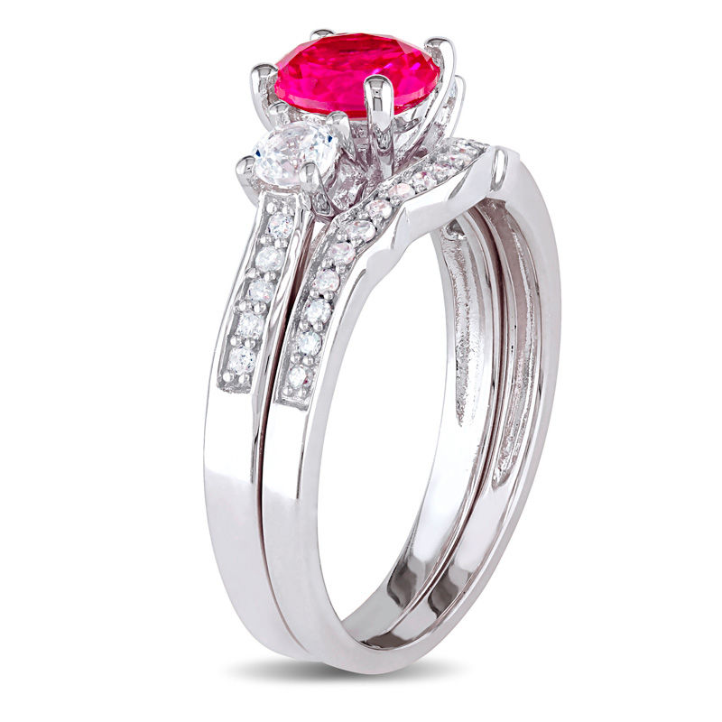 6.0mm Ruby and White Sapphire with 1/8 CT. T.W. Diamond Three Stone Bridal Set in 10K White Gold